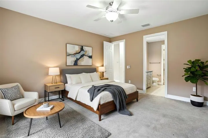 (Staged) Bedroom featuring carpet, a ceiling fan, and ensuite bathroom