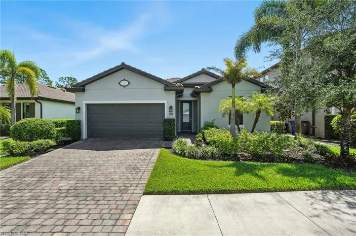 Ranch-style house featuring decorative driveway, stucco siding, and a garage
