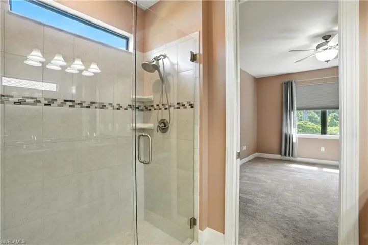 Full bath with healthy amount of natural light, a stall shower, and ceiling fan