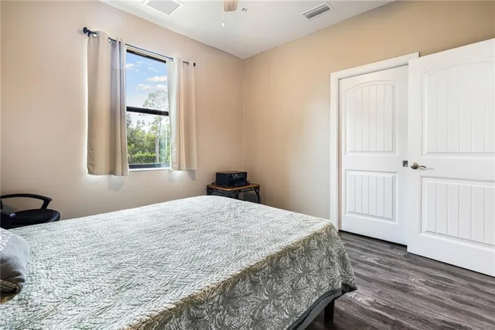 Bedroom with a closet, ceiling fan, and dark hardwood / wood-style flooring