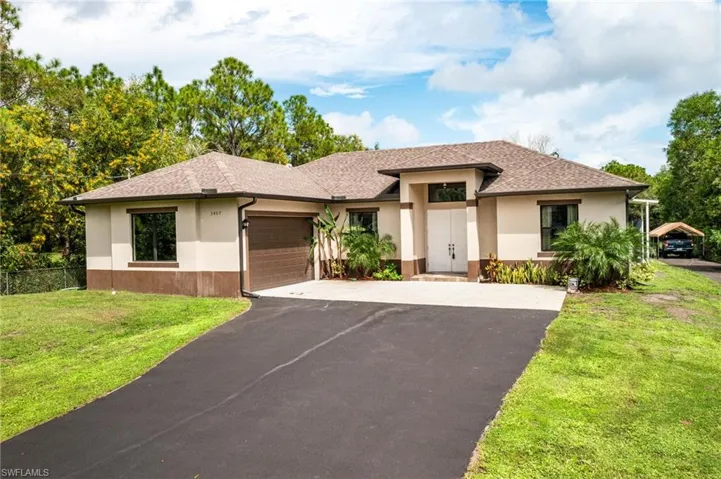 Prairie-style home featuring a garage, a carport, and a front lawn