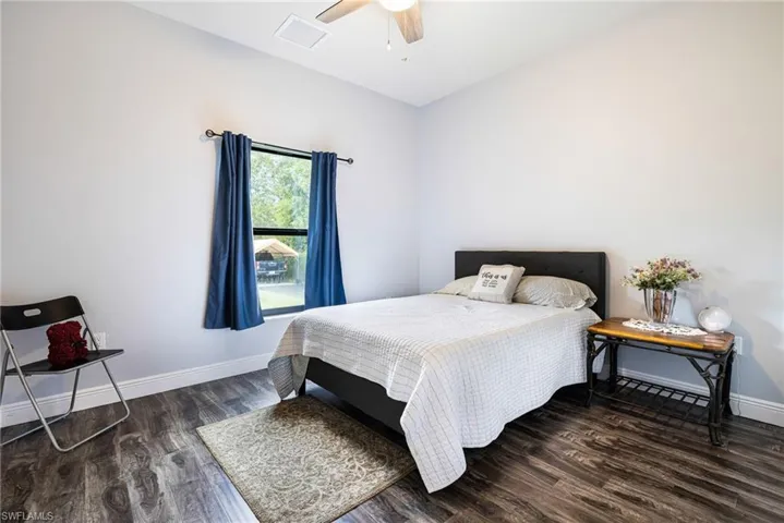 Bedroom with ceiling fan and dark hardwood / wood-style flooring