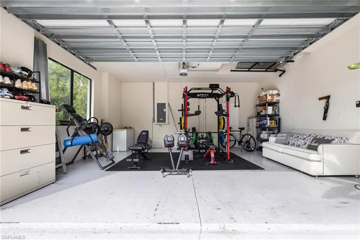 Garage featuring electric panel and a garage door opener
