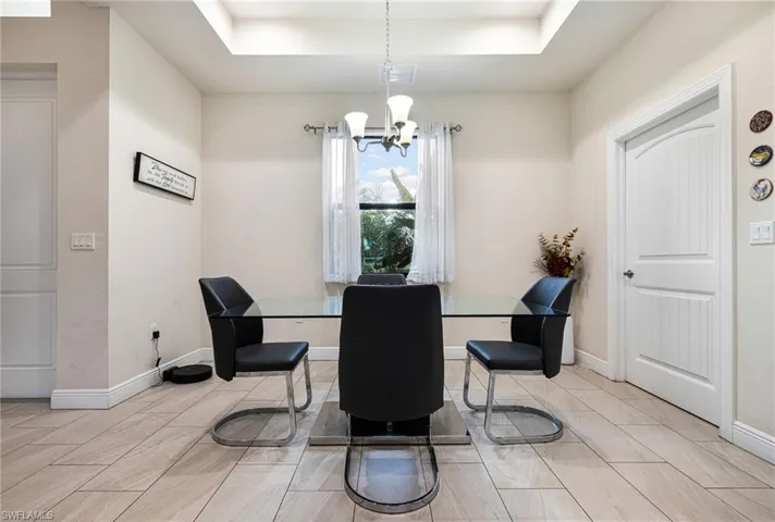 Dining space with a tray ceiling and an inviting chandelier