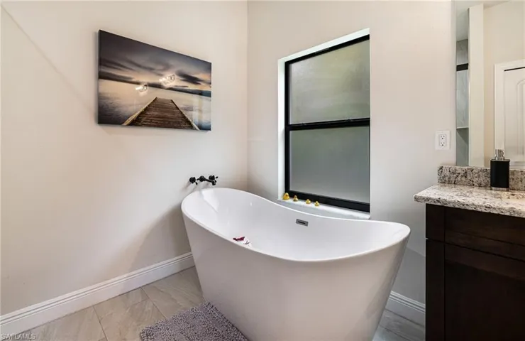 Bathroom featuring a tub to relax in and vanity