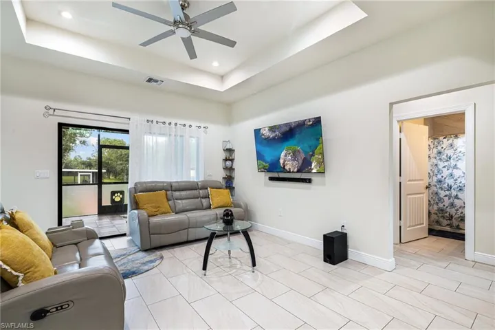 Living room with ceiling fan and a raised ceiling