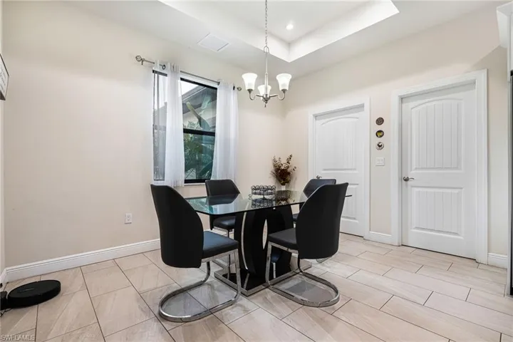 Dining area featuring a tray ceiling and a notable chandelier