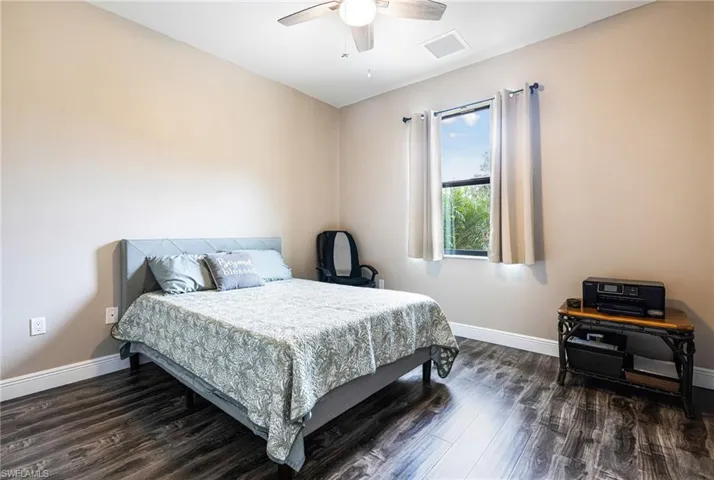 Bedroom with ceiling fan and dark wood-type flooring