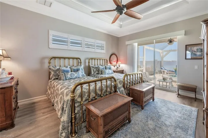 OWNER'S BEDROOM W/LUXURY VINYL FLOORING & SLIDERS TO LANAI & RIVER VIEW