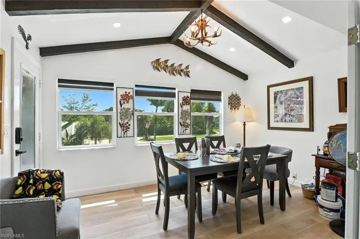 Vaulted ceiling with exposed wood beams and recessed lighting