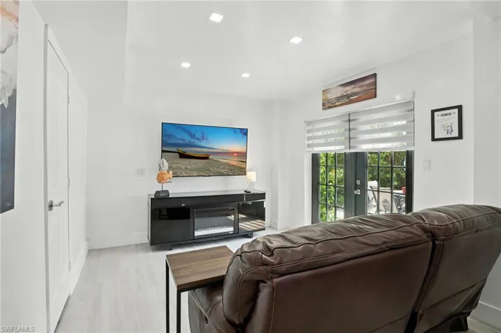 Room featuring light wood-finish flooring, recessed lighting, and a white color palette