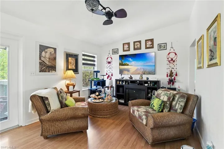 Living area featuring wood-finish flooring, a vaulted ceiling, and recessed lighting