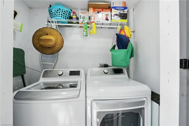 Dedicated laundry area featuring a white top-load washing machine and white front-load dryer