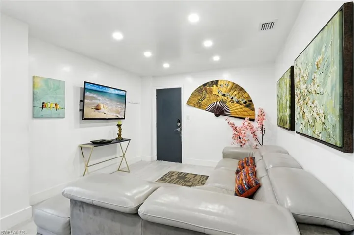 Recessed ceiling lighting illuminates the interior space, featuring light-toned flooring and white walls
