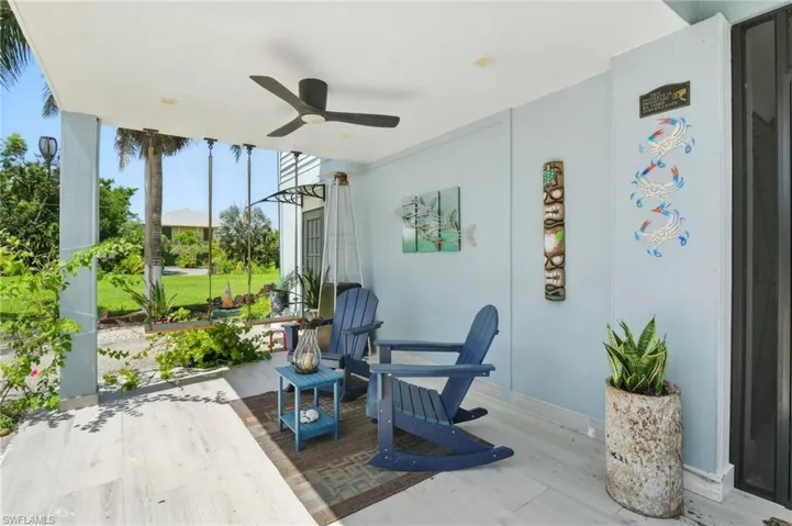 Covered outdoor patio featuring light-toned wood-finish flooring and a ceiling fan