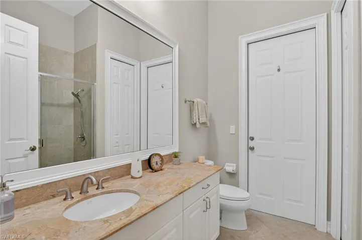 Full bathroom with a shower stall, vanity, a closet, and light tile patterned floors