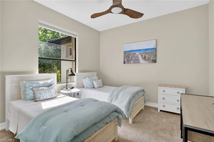 Carpeted bedroom featuring baseboards and ceiling fan