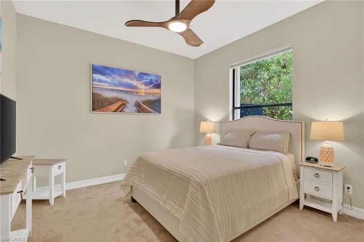 Bedroom with light carpet and a ceiling fan