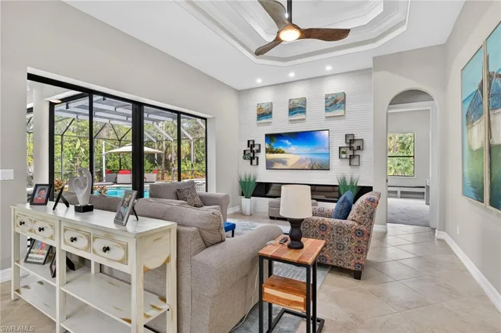 Living room featuring a ceiling fan, plenty of natural light, and light tile patterned flooring