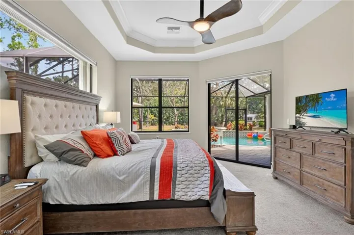 Bedroom featuring ornamental molding, a sunroom, carpet flooring, access to exterior, and a ceiling fan