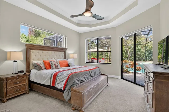Bedroom featuring crown molding, access to exterior, multiple windows, ceiling fan, and light colored carpet