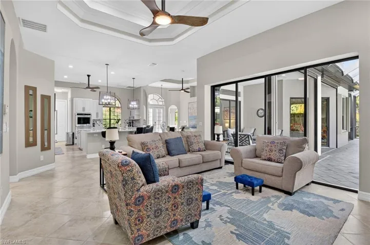 Living area featuring ceiling fan, ornamental molding, and a raised ceiling