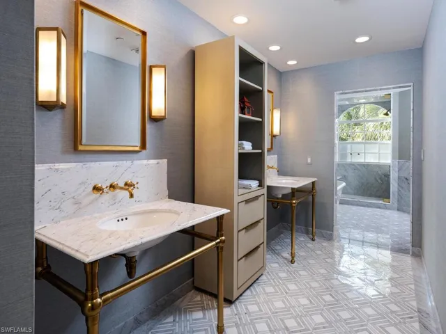 Full bath with a soaking tub, recessed lighting, tile patterned floors, and two sinks