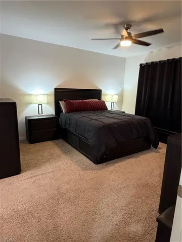 Bedroom featuring neutral carpeting and a ceiling fan with integrated lighting
