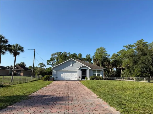 Single-story residence featuring a two-car garage and a brick paver driveway