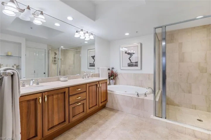 Bathroom with vanity, tile patterned floors, and plus walk in shower