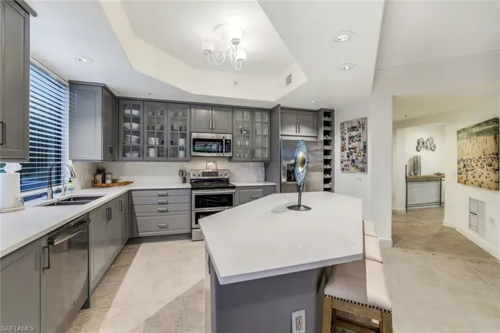 Kitchen with a center island, stainless steel appliances, sink, and gray cabinetry