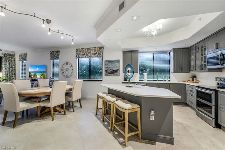 Kitchen featuring gray cabinetry, stainless steel appliances, sink, and an island with sink