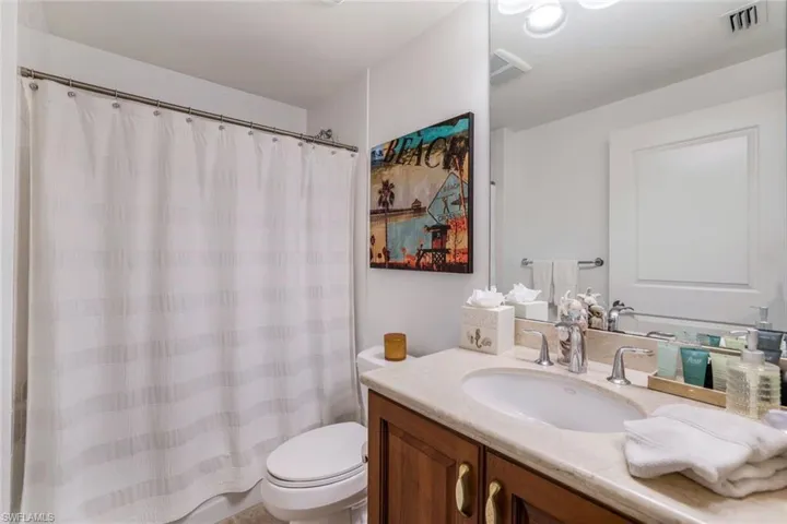 Bathroom featuring vanity, toilet, and a shower with shower curtain