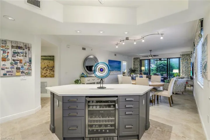 Kitchen with a center island, ceiling fan, gray cabinetry, and beverage cooler