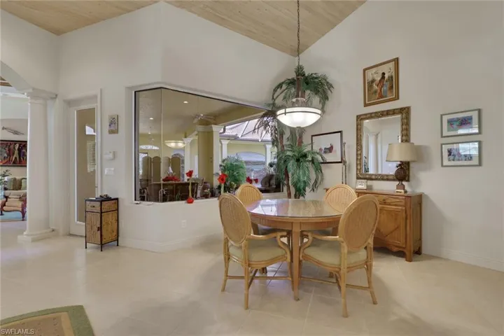 Dining space with ornate columns, wooden ceiling, and light tile patterned floors