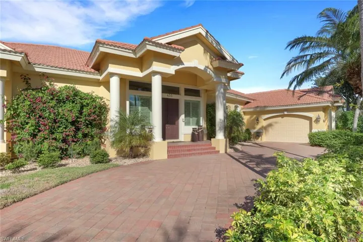 Mediterranean / spanish home with stucco siding, decorative driveway, an attached garage, a tiled roof, and a porch