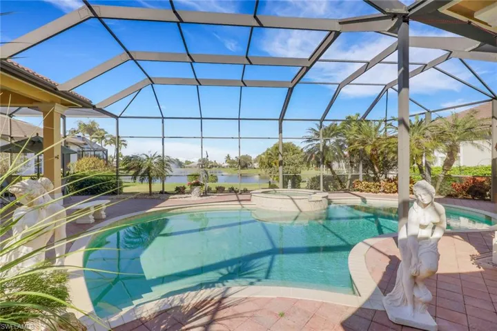 View of swimming pool featuring a sunroom, a pool with connected hot tub, and glass enclosure