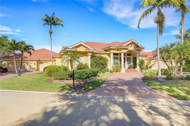 Mediterranean / spanish house with stucco siding, a front lawn, and decorative driveway