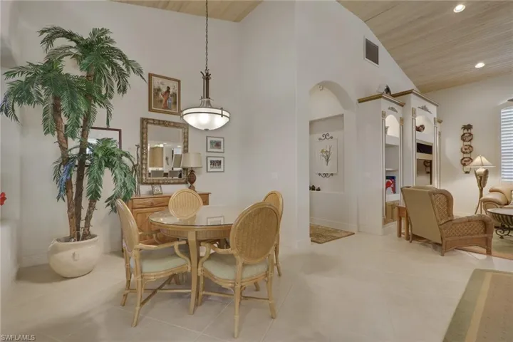Dining area featuring arched walkways, high vaulted ceiling, wooden ceiling, recessed lighting, and light tile patterned floors