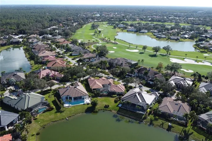 View of property location featuring a nearby body of water, nearby suburban area, and a local golf course