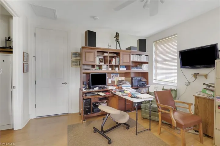 Home office with light wood-style floors and ceiling fan