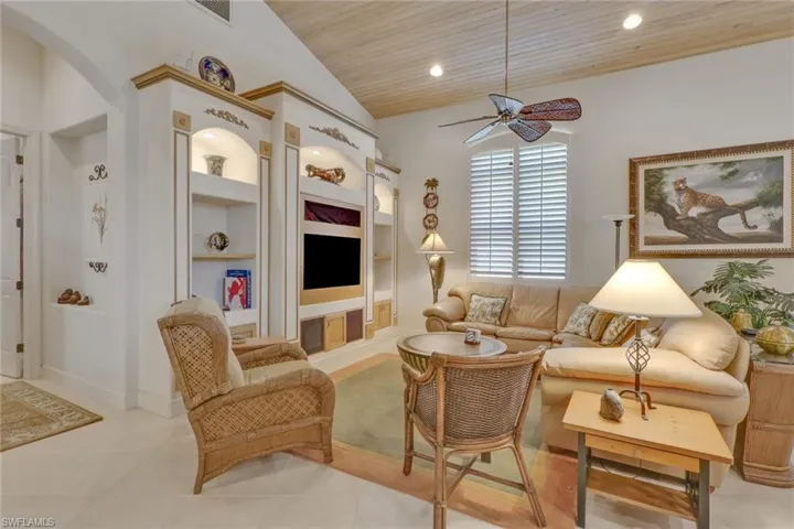 Tiled living room featuring built in features, wood ceiling, ceiling fan, lofted ceiling, and recessed lighting