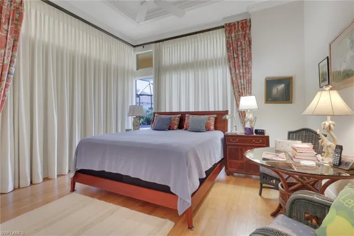 Bedroom featuring crown molding, light wood-type flooring, and a ceiling fan