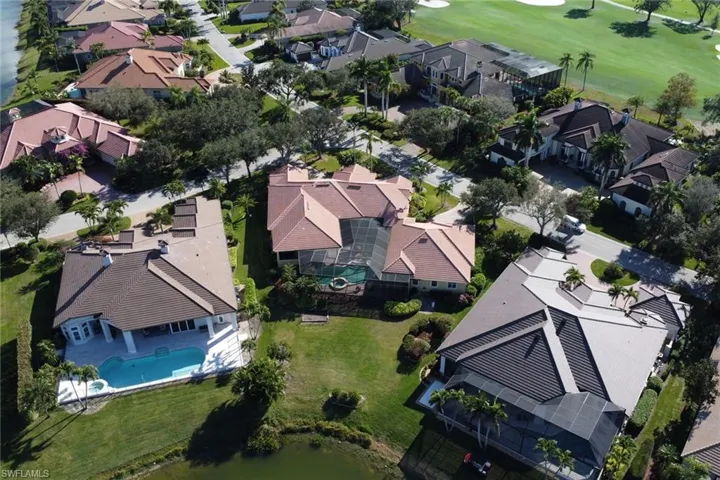 Aerial view of residential area with a golf club and a pool