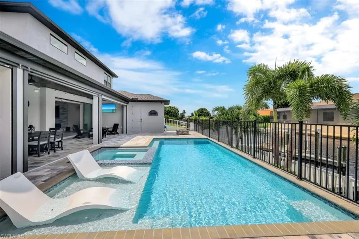 View of swimming pool featuring a fenced backyard, a patio, and a pool with connected hot tub