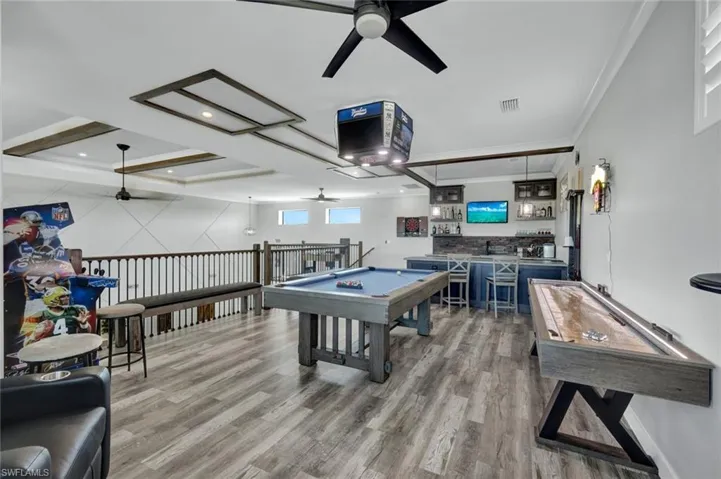 Game room featuring wet bar, pool table, a ceiling fan, recessed lighting, and crown molding-Yankee signs can be changed to different team
