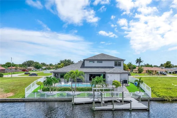 Dock area with a fenced backyard, a water view, and a swimming pool