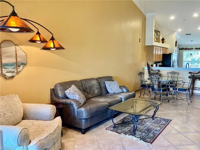 Living area with light tile patterned flooring, recessed lighting, and crown molding