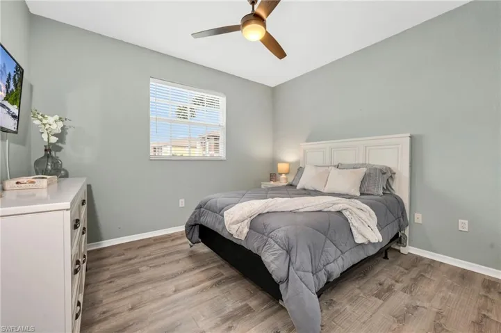 Guest Bedroom featuring new LVP - light wood style flooring and ceiling fan