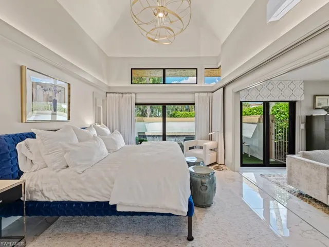 Primary bedroom with tray ceiling and custom light fixture